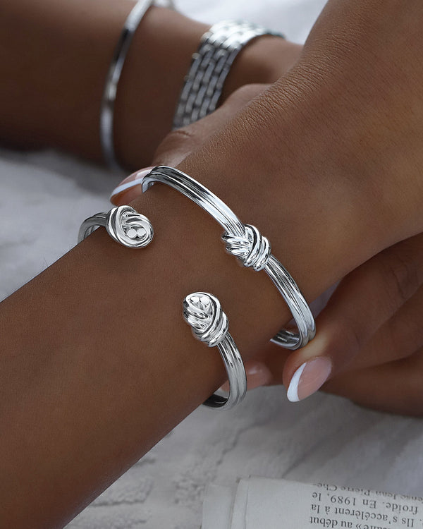 A Bangle Bracelet in polished Silver plated-316L stainless steel from Waldor & Co. The model is Dual Knot Bangle Polished.