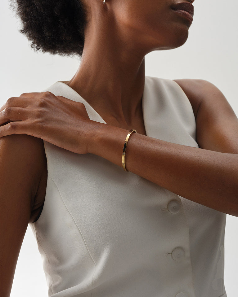 A Bangle Bracelet in 14k gold-plated stainless steel from Waldor & Co. The model is Brilliant Bangle Polished.