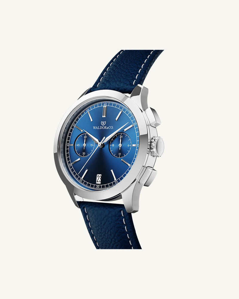 A round mens watch in rhodium-plated silver from Waldor & Co. with blue sunray dial and genuine blue leather strap. A second hand. Seiko movement. The model is Chrono 39 Sardinia 39mm.