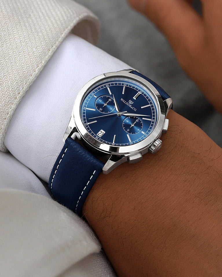 A round mens watch in rhodium-plated silver from Waldor & Co. with blue sunray dial and genuine blue leather strap. A second hand. Seiko movement. The model is Chrono 44 Sardinia 44mm.