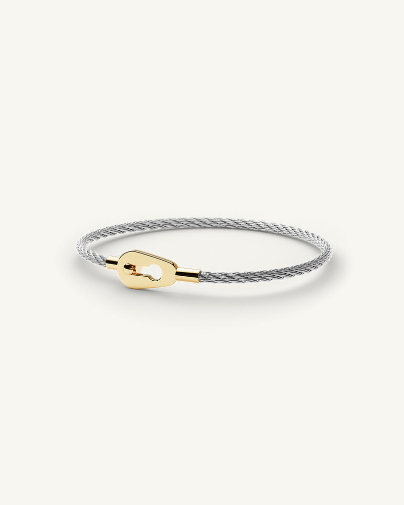 A Bangle in polished silver and 14k gold in 316L stainless steel from Waldor & Co. One size. The model is Como Cable Polished.