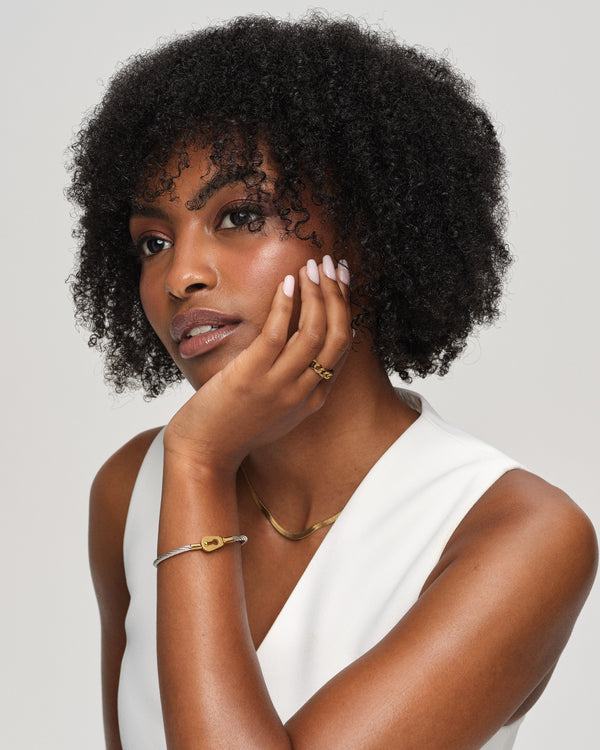 A Bangle in polished silver and 14k gold in 316L stainless steel from Waldor & Co. One size. The model is Como Cable Polished.