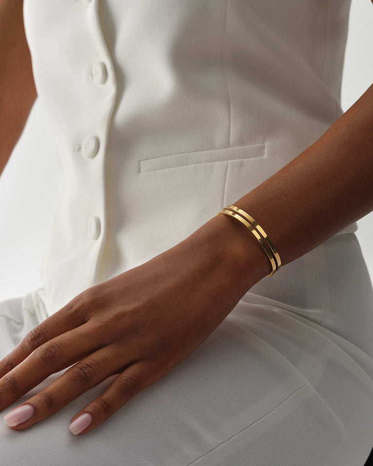 A Bangle in 14k gold plated 316L stainless steel from Waldor & Co. One size. The model is Dual Bangle Polished.