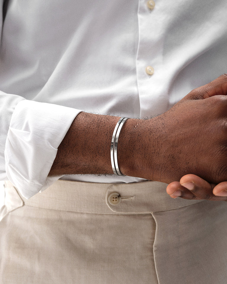 A polished stainless steel bangle in silver from Waldor & Co. One size. The model is Dual Bangle Polished.