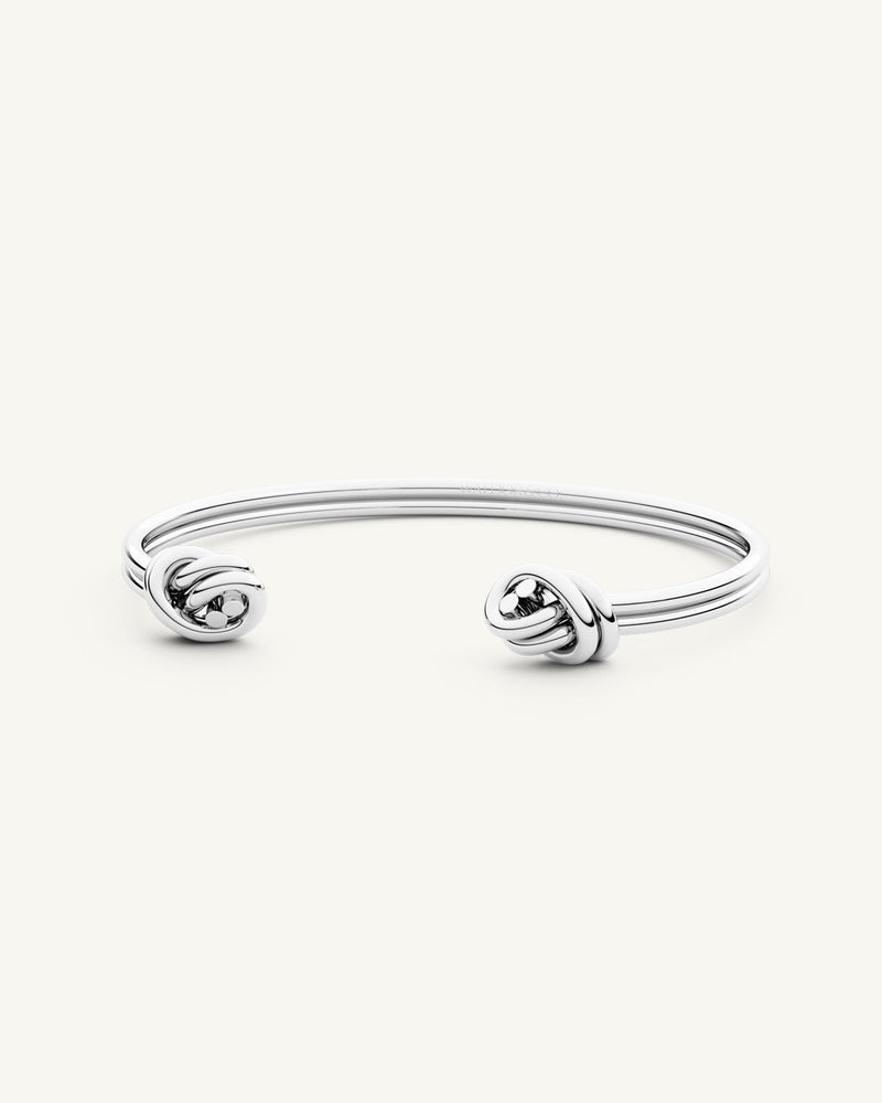 A Bangle Bracelet in polished Silver plated-316L stainless steel from Waldor & Co. The model is Dual Knot Bangle Polished.