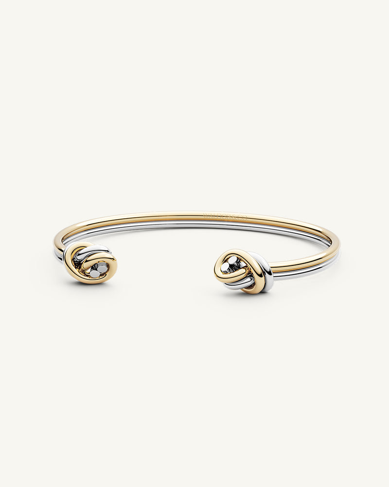 A Bangle in 14k-gold plated and silver polished 316L stainless steel from Waldor & Co. One size. The model is Dual Knot Bangle Polished.