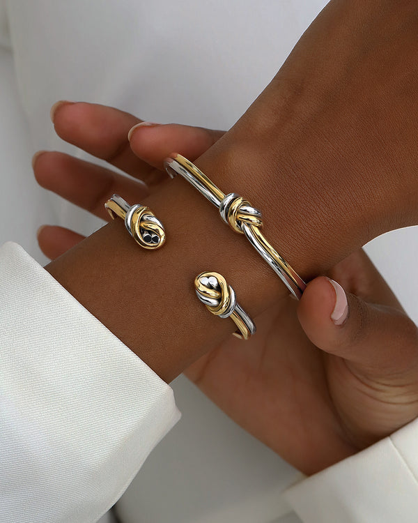 A Bangle in 14k-gold plated and silver polished 316L stainless steel from Waldor & Co. One size. The model is Dual Knot Bangle Polished.