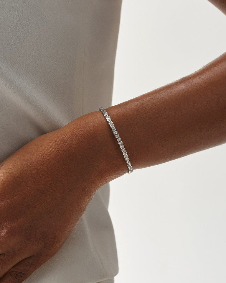 A polished stainless steel bangle in silver from Waldor & Co. One size. The model is Grace Bangle Polished