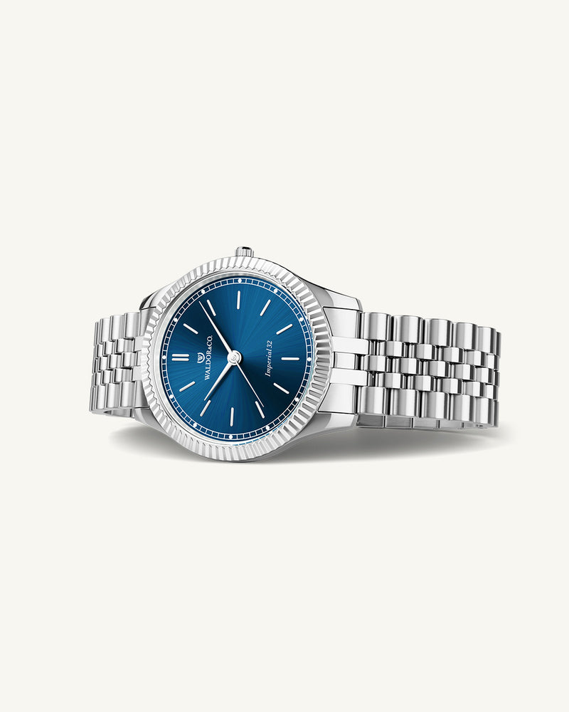 A round womens watch in silver from Waldor & Co. with blue sunray dial and a second hand. Seiko movement. The model is Imperial 32 Positano 32mm.