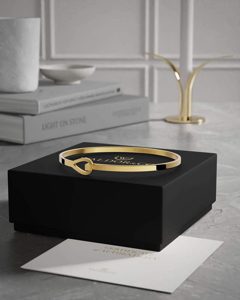 A Bangle Bracelet in 14k gold-plated from Waldor & Co. The model is Signature Bangle Polished Gold