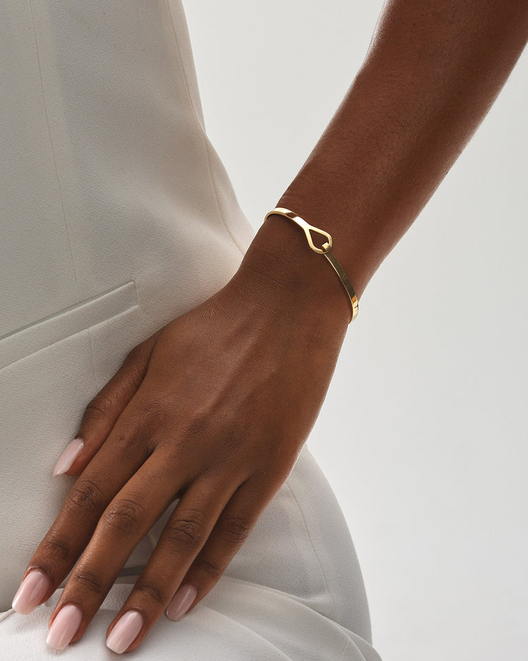 A Bangle in 14k gold plated 316L stainless steel from Waldor & Co. One size. The model is Signature Bangle Polished.