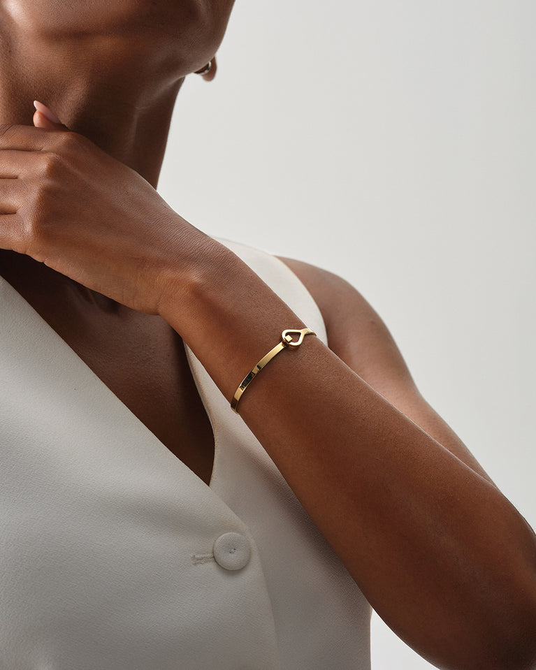 A Bangle in 14k gold plated 316L stainless steel from Waldor & Co. One size. The model is Signature Bangle Polished.