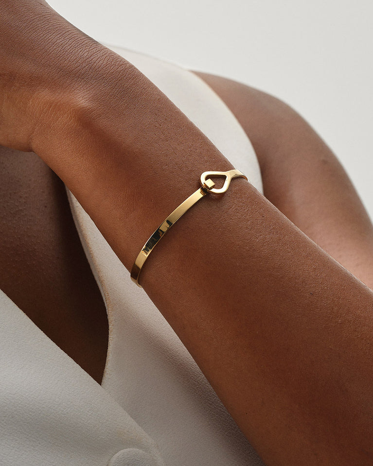 A Bangle in 14k gold plated 316L stainless steel from Waldor & Co. One size. The model is Signature Bangle Polished.