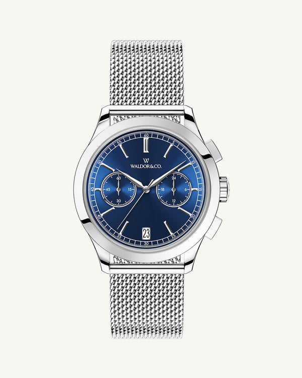 En rund herrklocka i rodiumpläterat silver från WALDOR & CO. med blå sunray urtavla och en sekundvisare. Seiko urverk. Modellen är Chrono 39 Sardinia 39mm. 