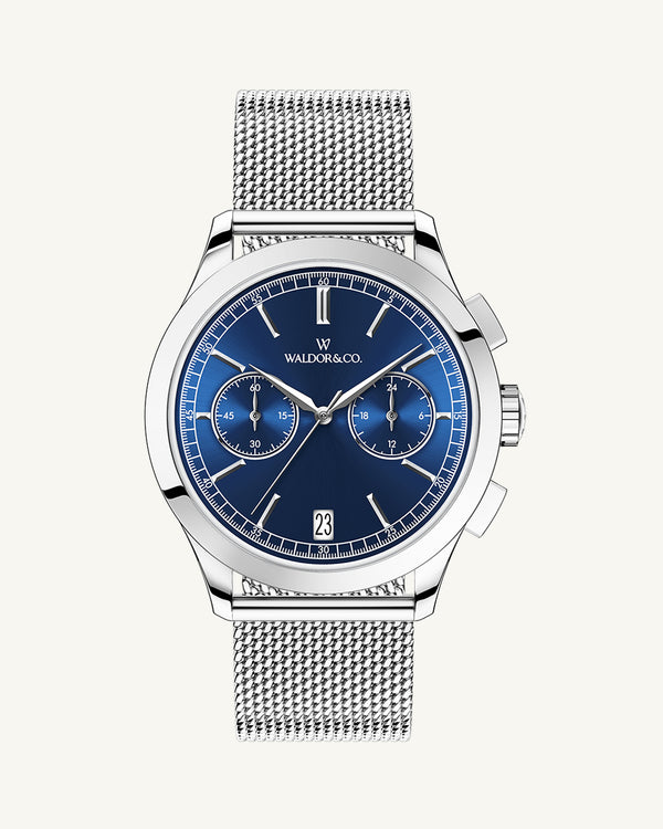 En rund herrklocka i rodiumpläterat silver från WALDOR & CO. med blå sunray urtavla och en sekundvisare. Seiko urverk. Modellen är Chrono 44 Sardinia 44mm. 