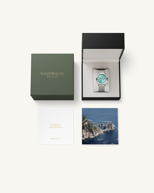A round mens watch in rhodium-plated silver from Waldor & Co. with turquoise sunray dial and a second hand. Seiko movement. The model is Chrono 44 Sardinia 44mm.