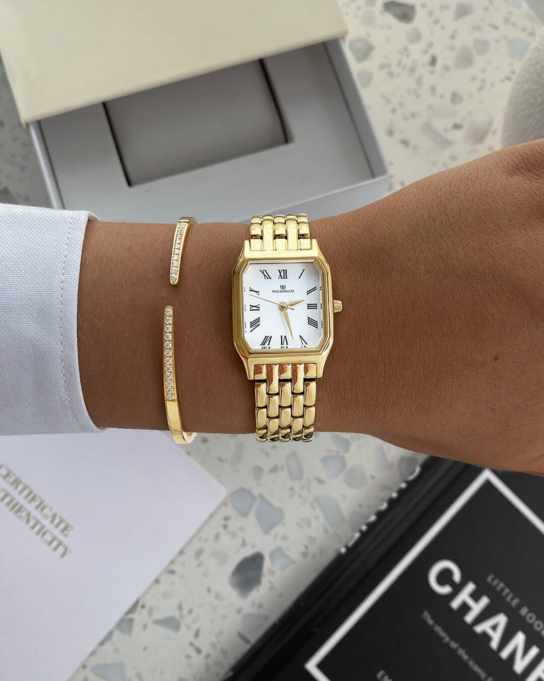 A square womens watch in 22k gold plated 316L stainless steel from Waldor & Co. with white Diamond Cut Sapphire Crystal glass dial. Seiko movement. The model is Eternal 22 Bellagio