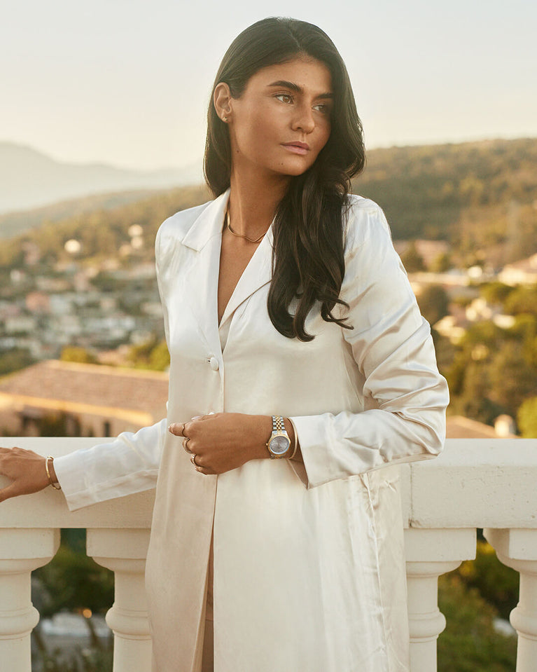 A round womens watch in silver and 22k gold from Waldor & Co. with silver sunray dial and a second hand. Seiko movement. The model is Imperial 32 Positano 32mm.